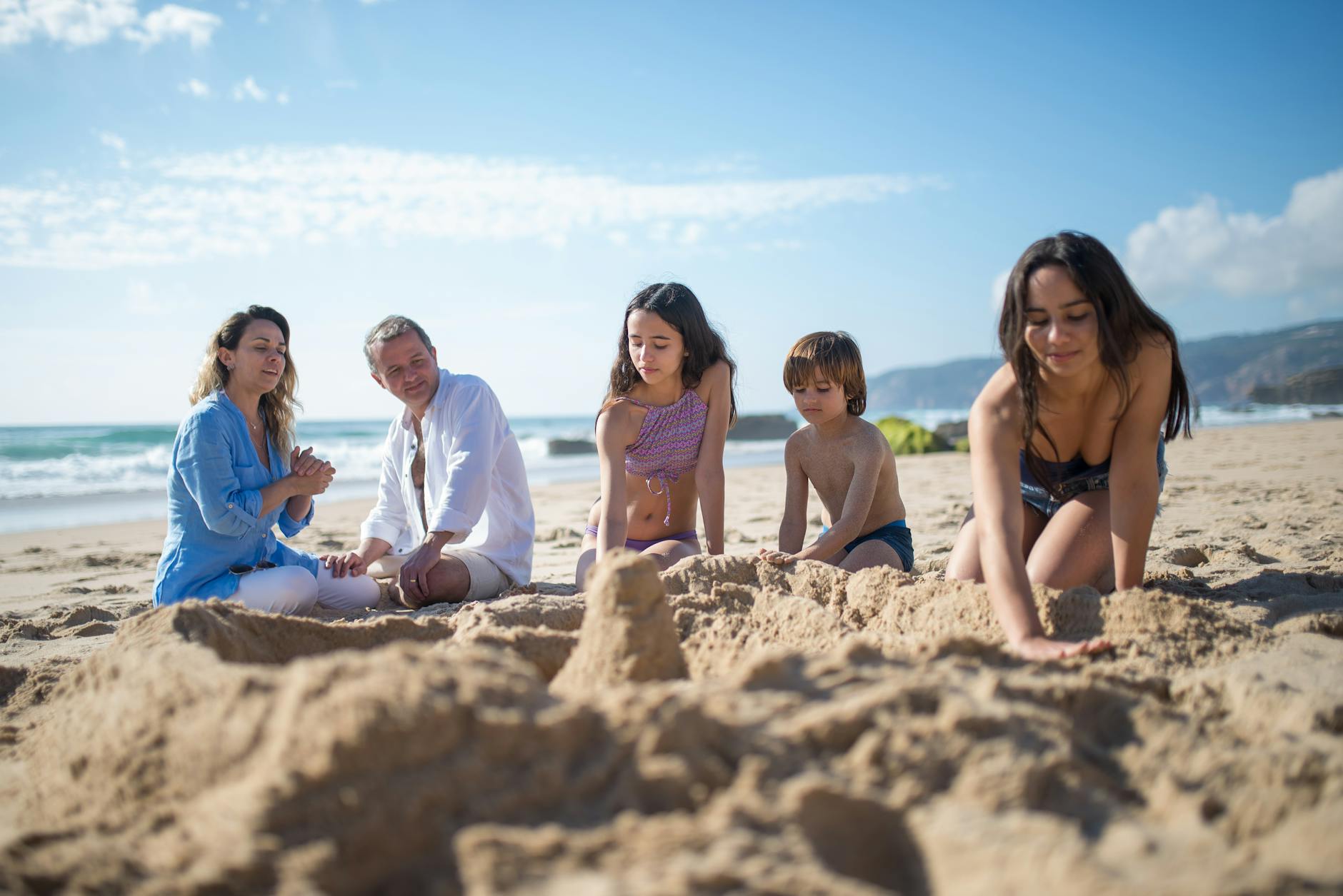 Family enjoying a day at a sandy Cornwall beach building sandcastles