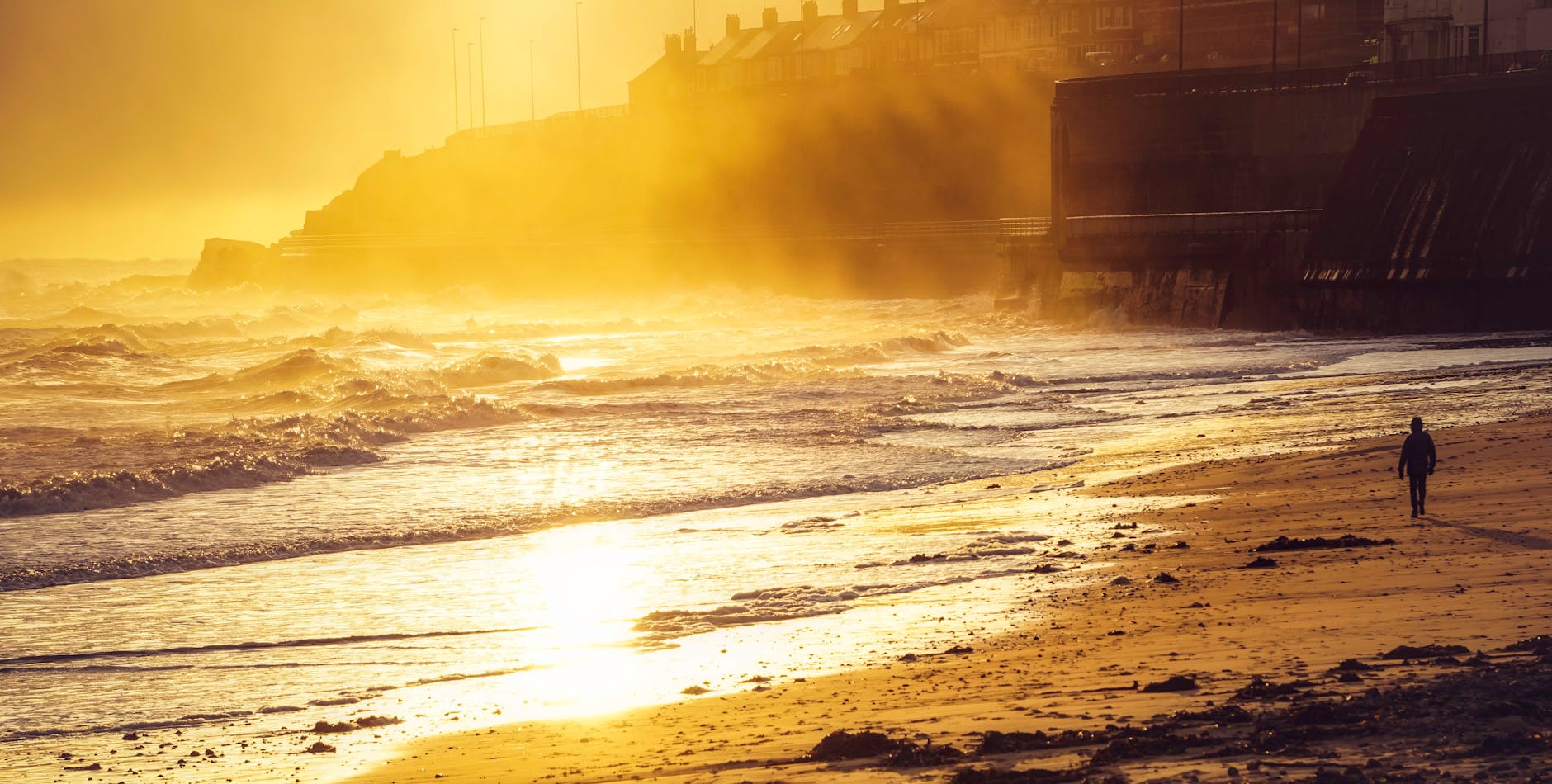 Golden sunset over a Cornwall beach with waves lapping the shore