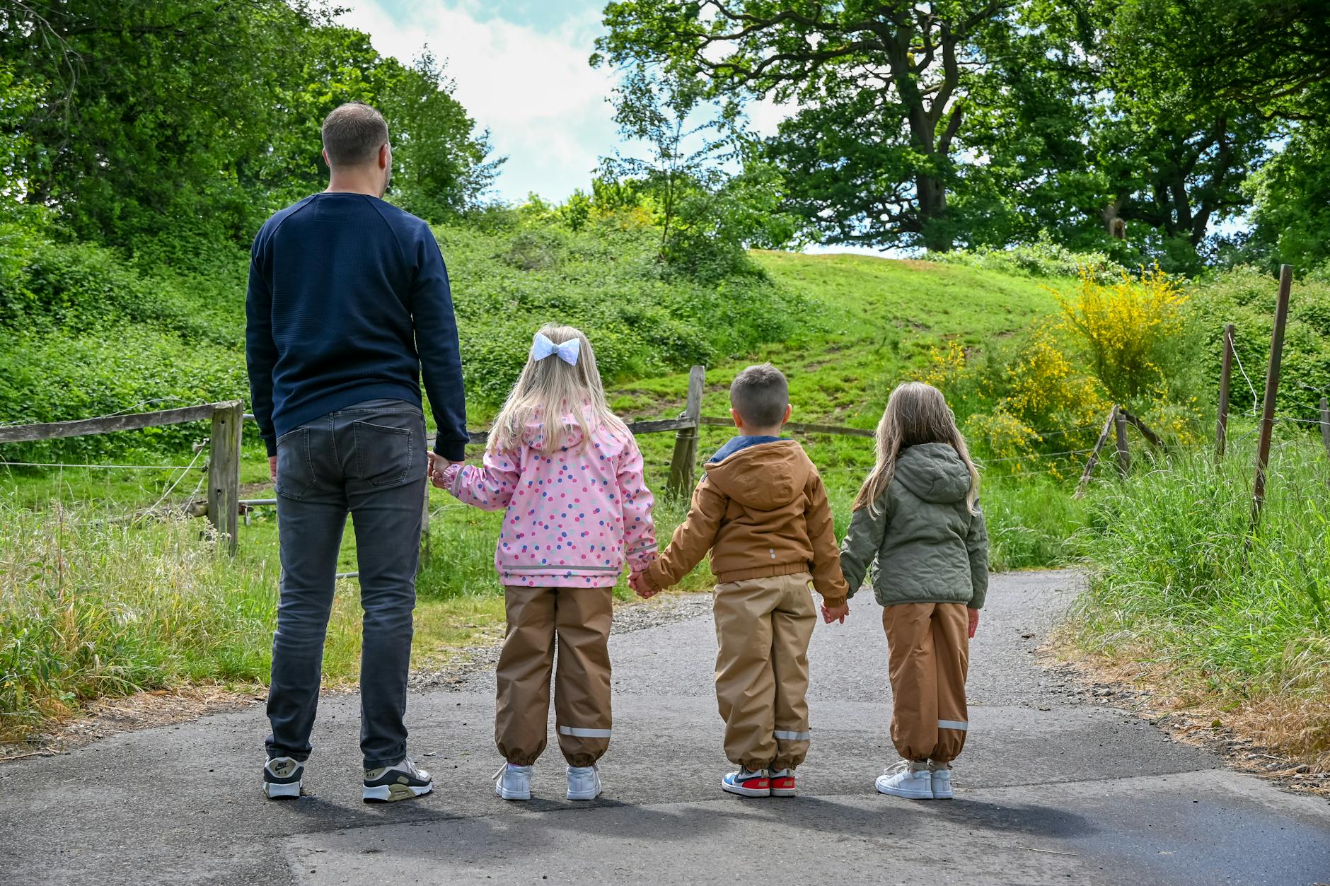 Family enjoying a walk along a countryside path in Cornwall with young children