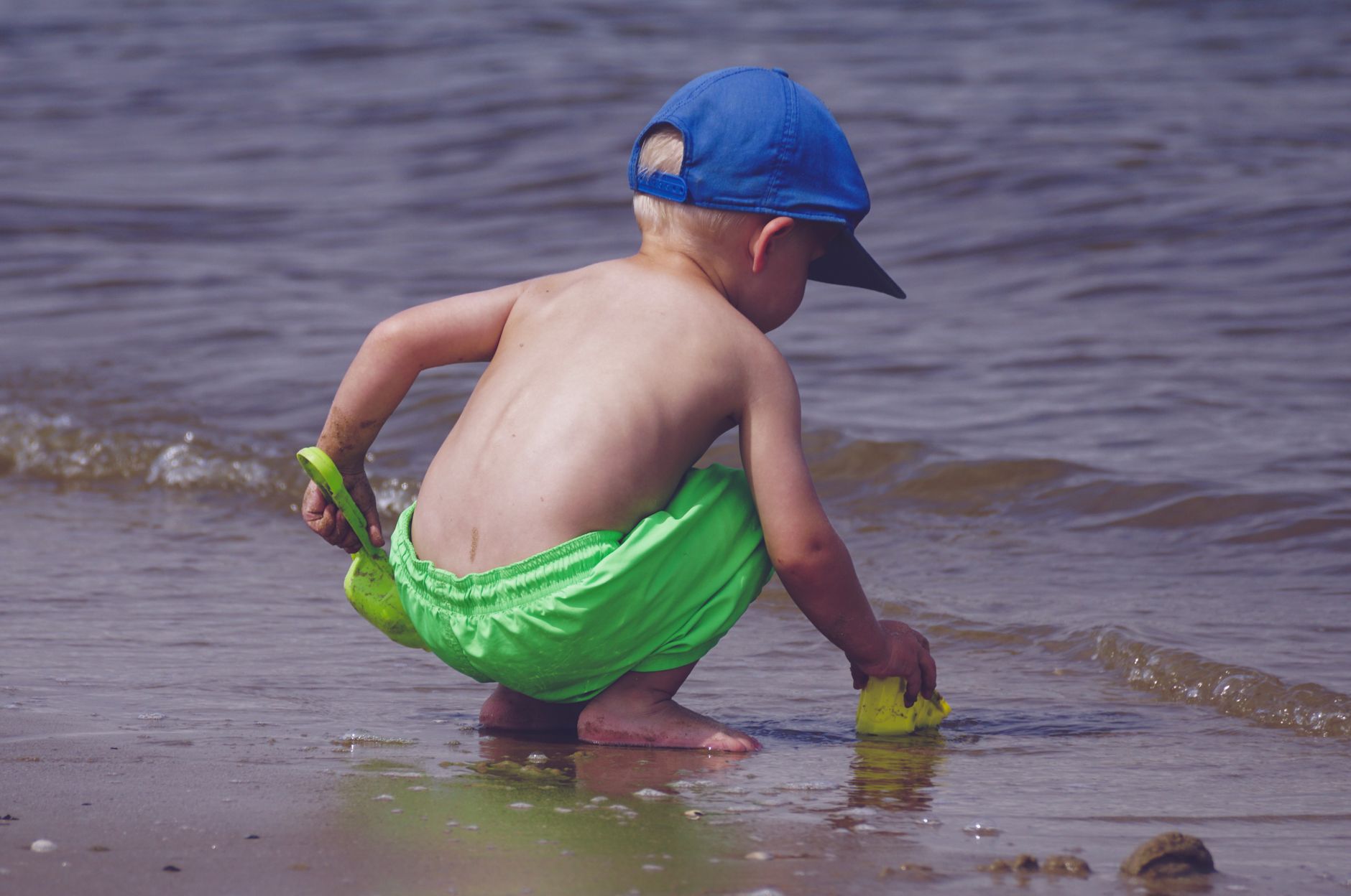 Baby toddler paddling shallow Cornwall beach water