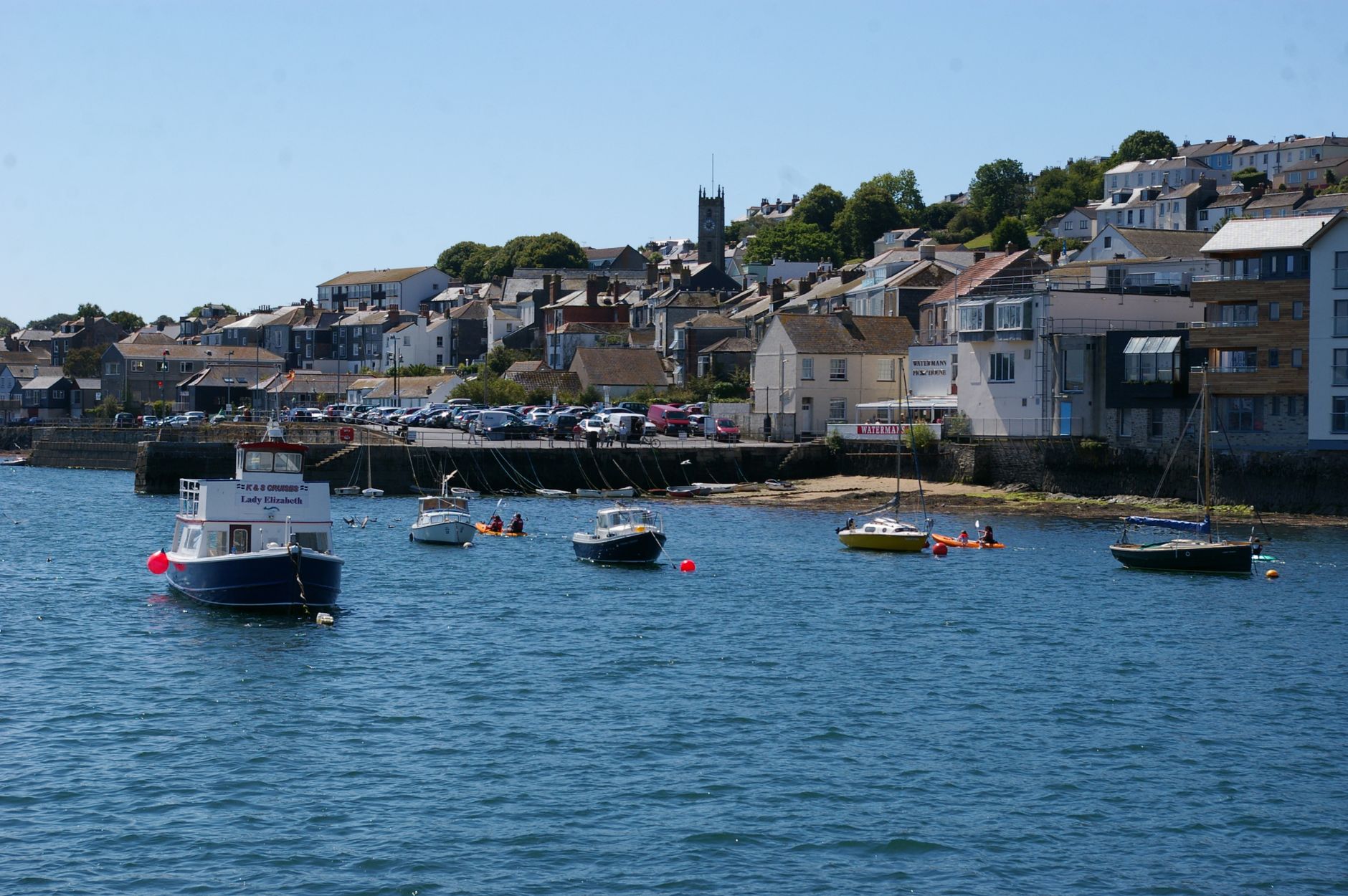 Boats moored in Falmouth's deep natural harbour on a bright morning in Cornwall