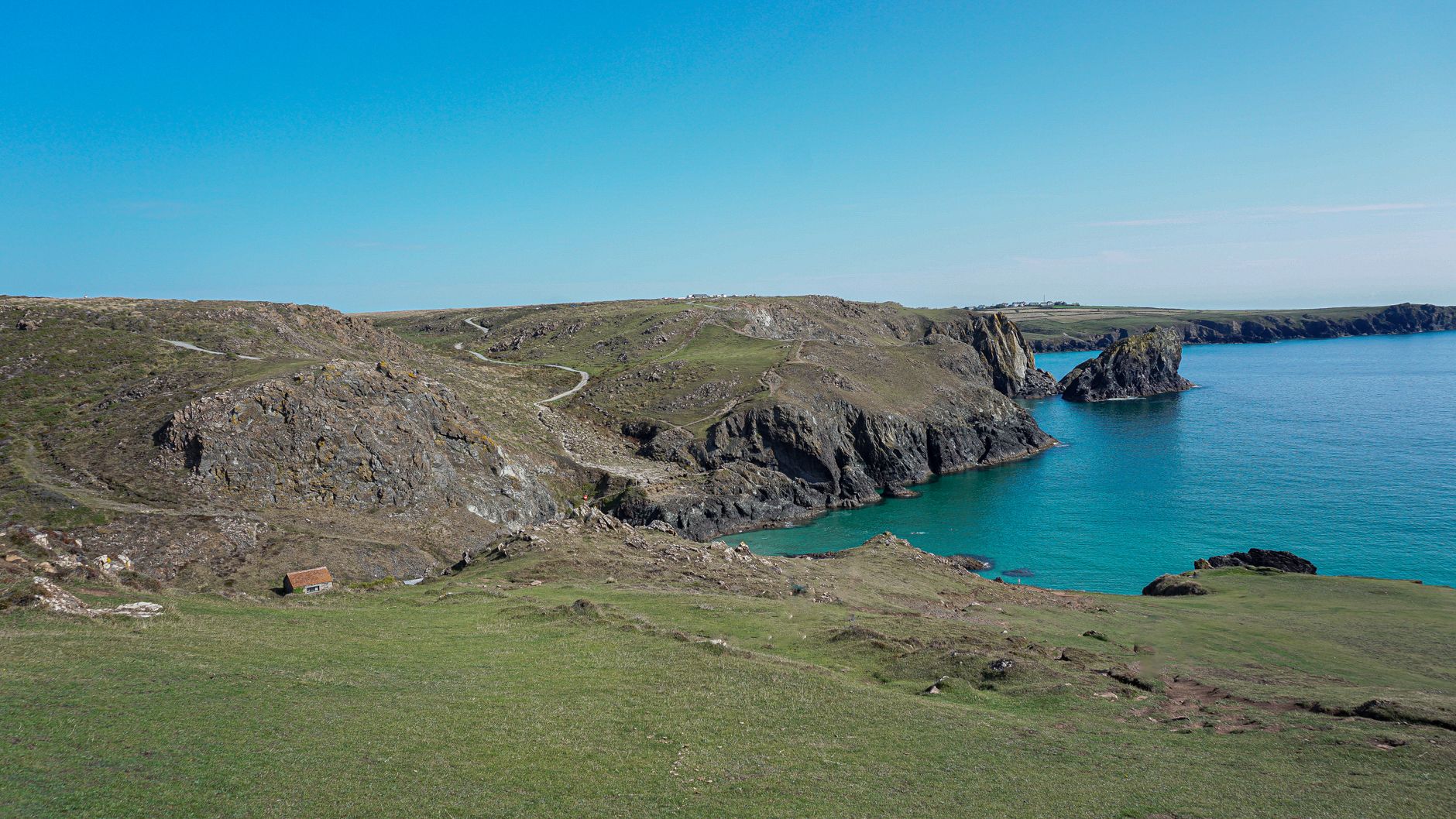 Secluded turquoise cove backed by cliffs on the Cornwall coast