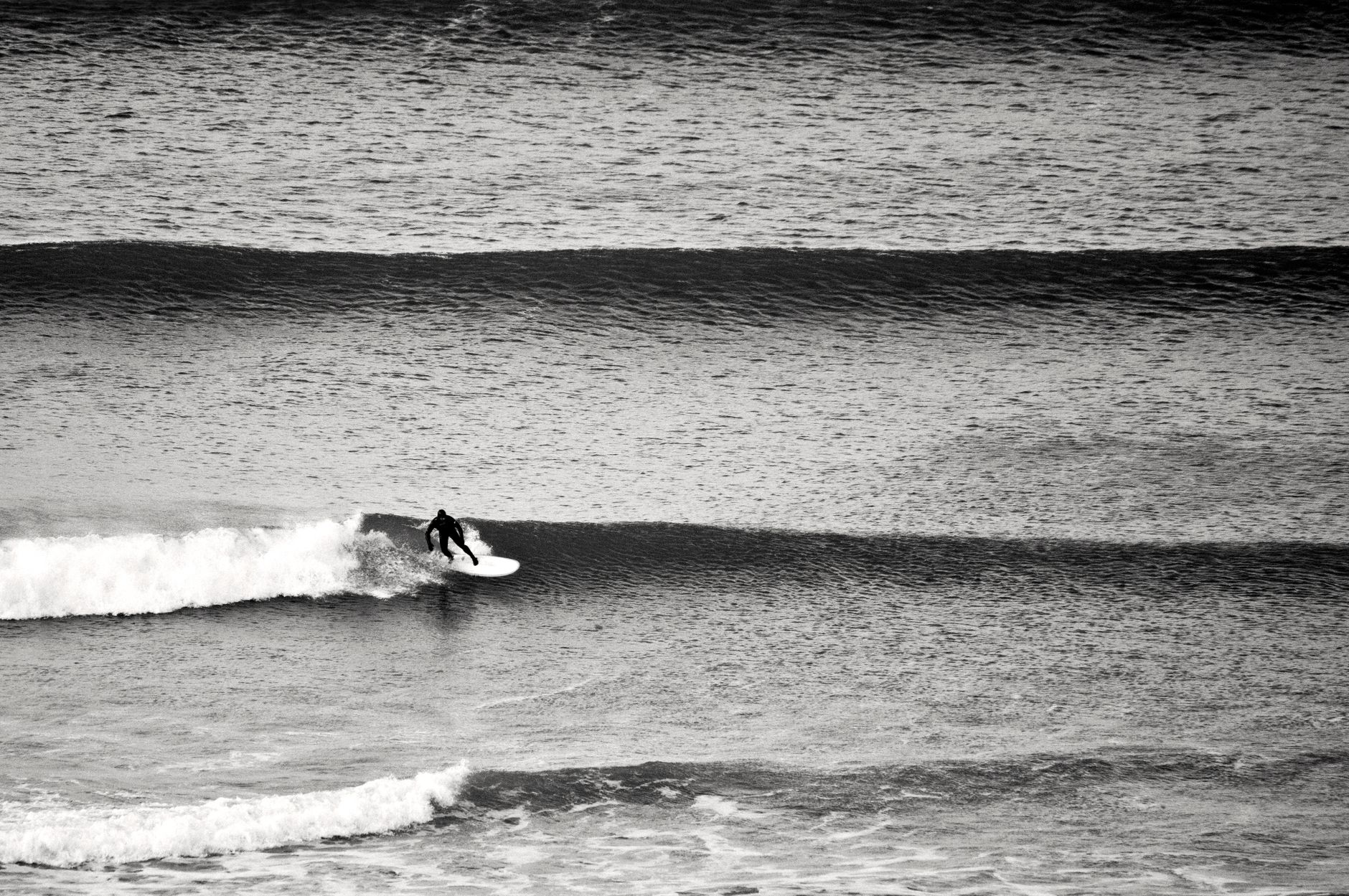 Surfer riding an Atlantic wave off a Cornwall beach
