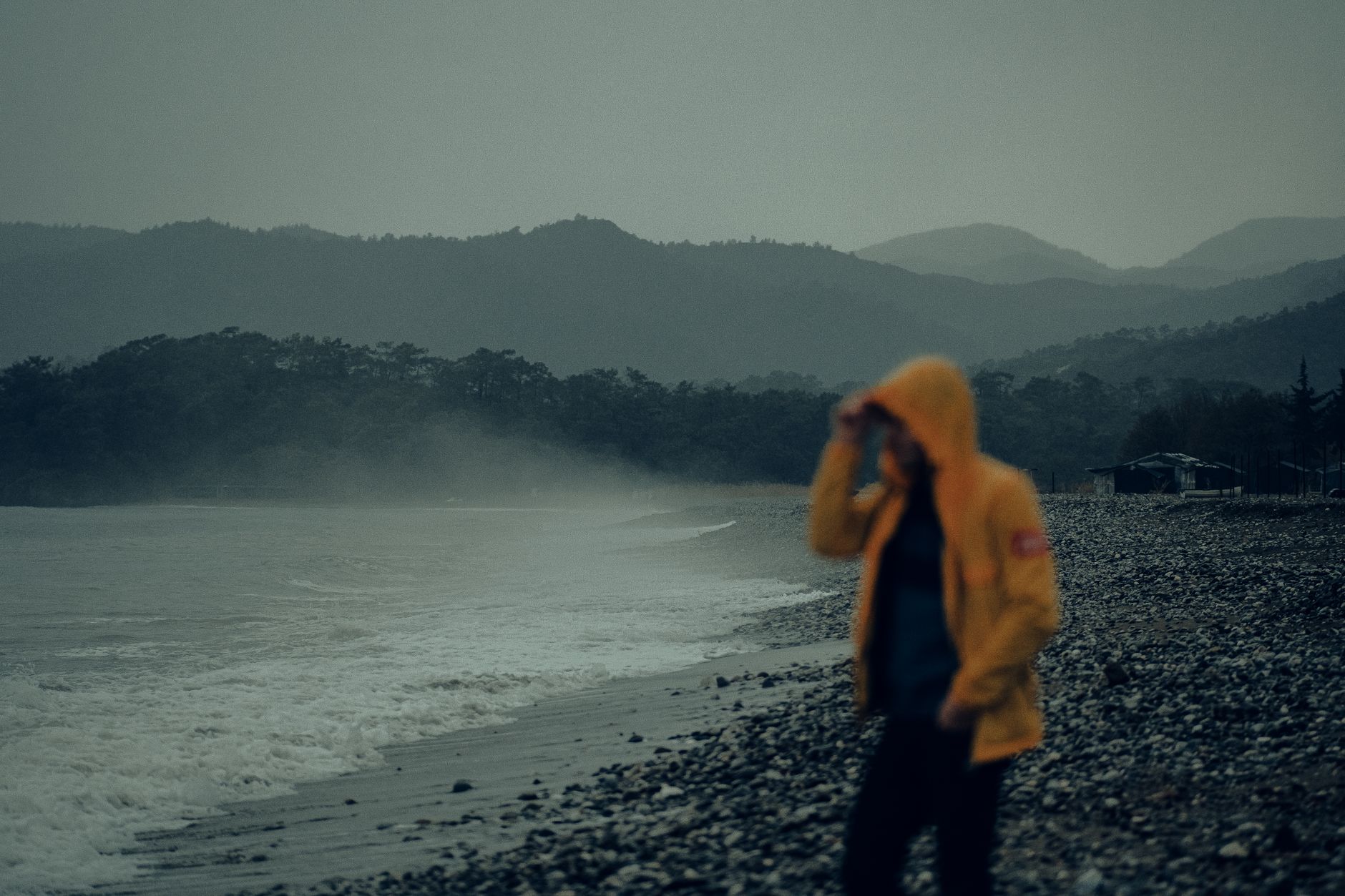Walker in a waterproof jacket on a rainy Cornish clifftop