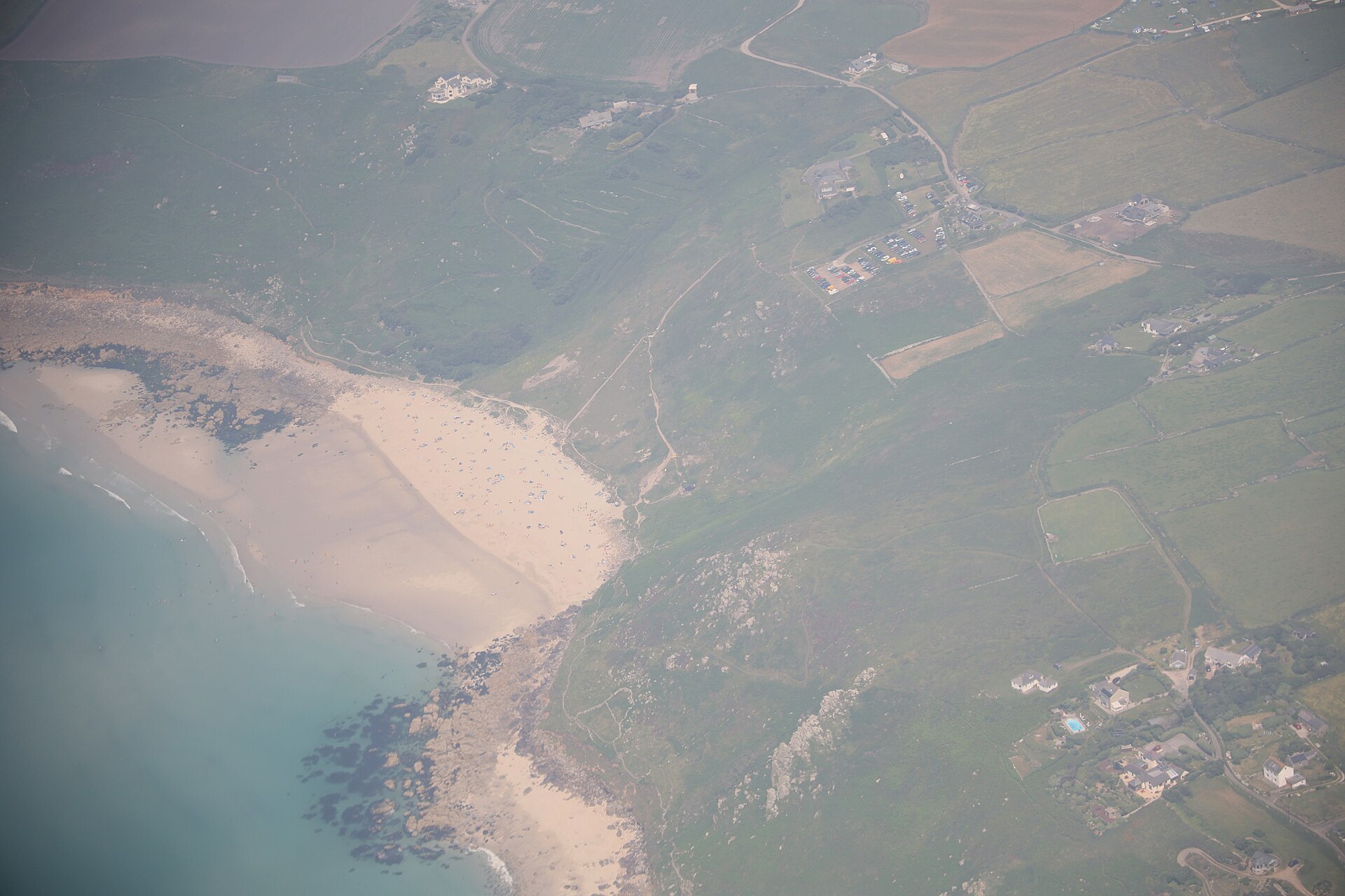 Aerial view of Gwenver beach, with the clifftop car park and the path down the hillside