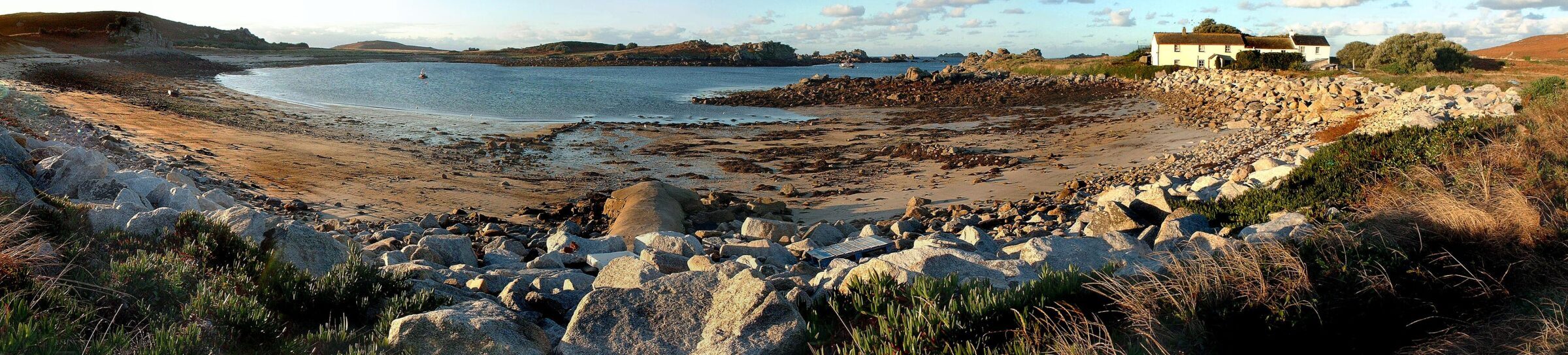 Hell's Bay cove on Bryher, Isles of Scilly, with a cottage above the beach
