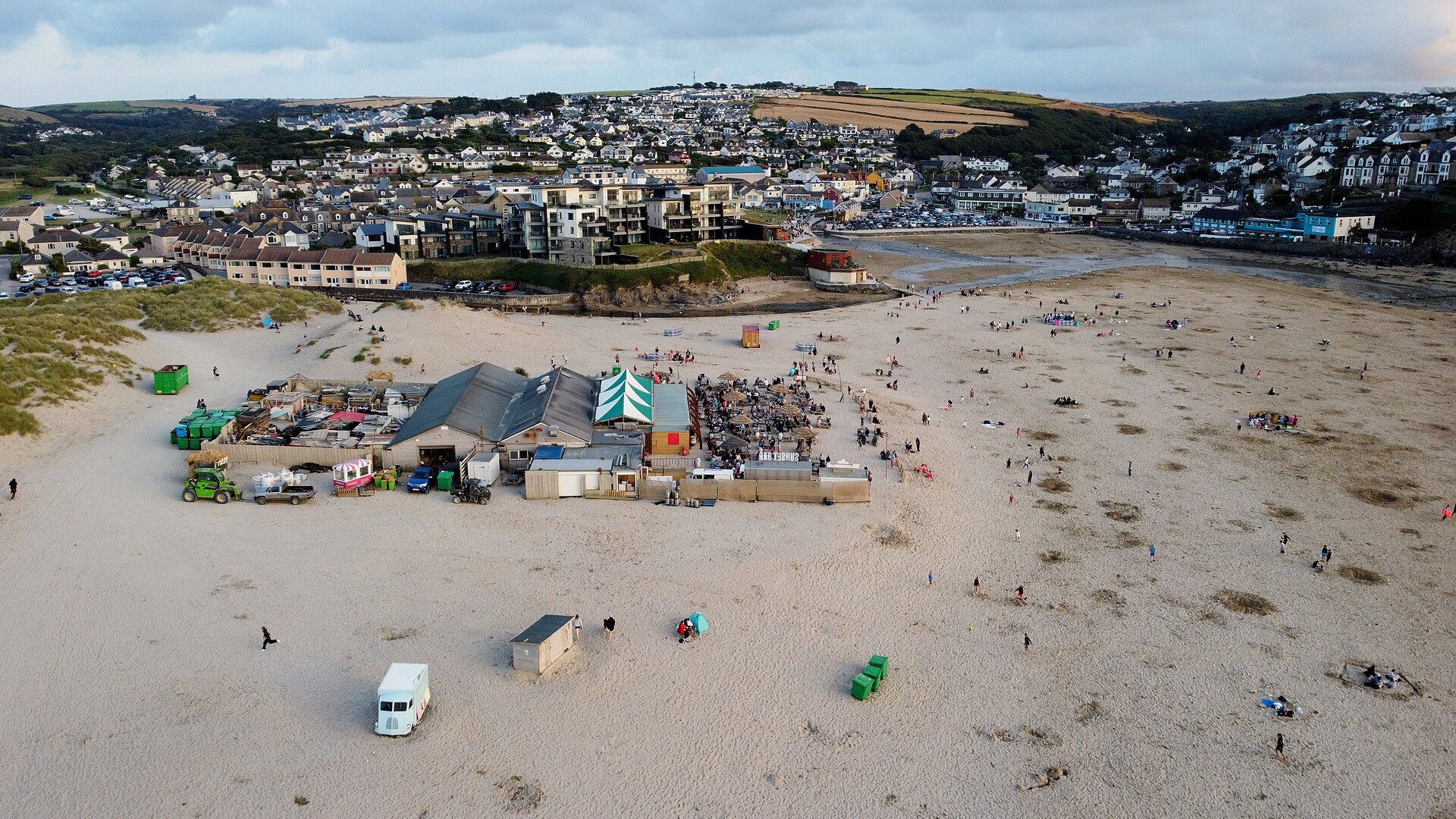 Aerial view of the Watering Hole bar on the sand at Perranporth beach, with the village behind