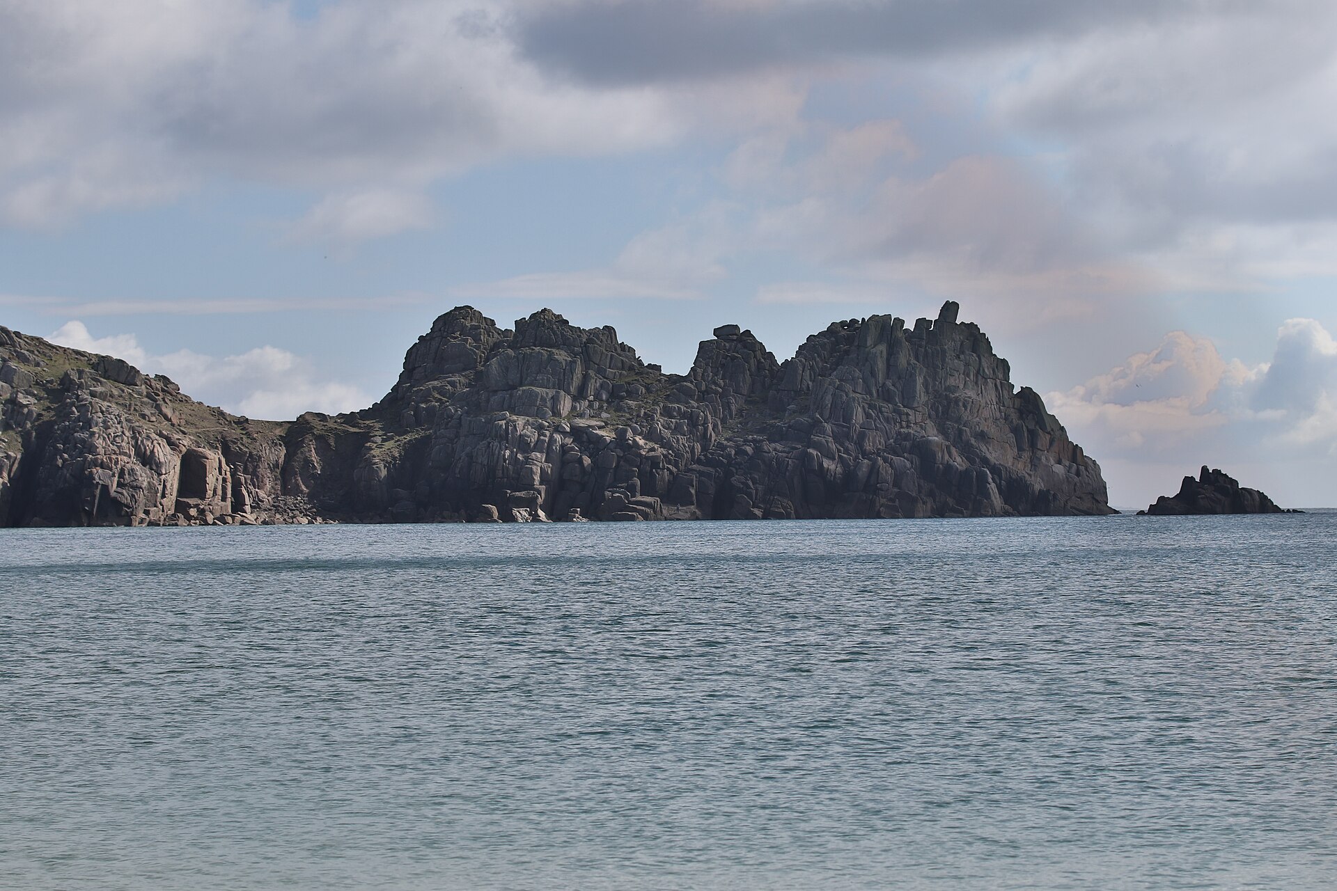 The granite headland of Treryn Dinas, home of the Logan Rock, seen across the sea from Porthcurno